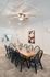 Elegant dining area featuring a long wooden table with stylish black chairs under a modern ceiling fan, perfect for gatherings.