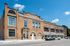 Charming historic building with brick facade and large windows under a clear blue sky, perfect for modern city living.