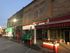 Charming street view of a historic commercial building with inviting storefronts and ambient evening lighting.