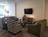 Inviting living room with cozy sofas, elegant checkered chairs, and a mounted TV, perfect for relaxation.