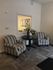 Cozy corner with elegant striped armchairs and a stylish table, perfect for relaxation in a contemporary apartment setting.