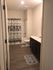 Contemporary bathroom with elegant decor, featuring a floral shower curtain and stylish wood flooring.