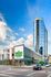 Modern glass high-rise with Whole Foods Market at the base, offering upscale urban living in a prime location.