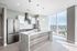 Modern kitchen with elegant marble island, stainless steel appliances, and breathtaking city views from floor-to-ceiling windows.