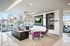 Sophisticated modern lounge with chic purple chairs, plush couch, and floor-to-ceiling windows offering stunning city views.