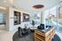 Contemporary lounge area featuring modern seating, stylish shelving, and panoramic city views through floor-to-ceiling windows.