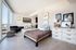 Modern apartment with stylish open-concept living space, featuring a cozy bed, elegant d&eacute;cor, and natural light from large windows.