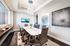 Elegant conference room with a sleek white table, comfortable modern chairs, and stunning abstract artwork, creating a professional ambiance.