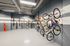 Modern bike storage room with sleek wall racks and vibrant orange accents, providing ample and organized space for bicycles.