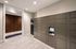 Modern apartment lobby featuring sleek parcel lockers with electronic access, accented by elegant dark wood paneling and bright overhead lighting.