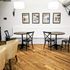 Charming dining area with wooden floors, cozy seating, modern lighting, and decorative wall art.