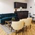 Elegant living space with a plush teal sofa, modern wooden cabinetry, and stylish dining area.