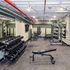 Modern gym facility with state-of-the-art equipment, including free weights, a bench, and strength training machines, perfect for fitness enthusiasts.