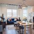 Charming loft-style living room with exposed brick, modern lighting, and cozy seating, perfect for urban living.