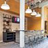 Chic commercial space with modern counter seating, stylish overhead lighting, and a contemporary shelving display.