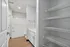 Modern bathroom featuring sleek white cabinetry, spacious shower-tub combo, and ample storage with wire shelving.