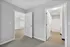 Bright hallway view highlighting a modern layout with light wood flooring, spacious bathroom, and open entry to living area.