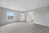 Bright and spacious bedroom with plush carpeting, large window offering stunning views, and a modern neutral palette.