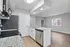 Modern kitchen with sleek granite countertops, stainless steel appliances, and an open layout leading to a bright living area.