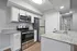 Modern kitchen with sleek stainless steel appliances, elegant granite countertops, and stylish white cabinetry.