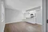 Modern open-floor apartment featuring a sleek kitchen with stainless steel appliances and elegant wood flooring.