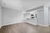 Contemporary open-concept apartment with elegant hardwood floors, featuring a sleek kitchen with modern stainless steel appliances.