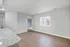 Bright and spacious open-concept living area with elegant wood flooring and a granite countertop, perfect for modern living.