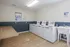 Modern laundry room with multiple washing machines, sleek design, and a convenient sink area.