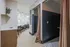 Sleek apartment interior featuring a modern seating area with stylish chairs, cozy corner with curtains, and elegant wood flooring.