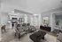 Modern living space featuring a stylish open kitchen with stainless steel appliances, inviting bar seating, elegant lounge area, and tasteful decor.