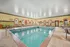 Inviting indoor pool area with stylish lounge chairs and arched windows, perfect for relaxation and leisure.