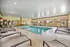 Inviting indoor swimming pool area with comfortable lounge chairs and natural light.