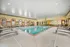 Spacious indoor pool area with elegant lounge chairs and arched windows, perfect for relaxation year-round.