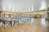 Inviting indoor pool area with elegant arched windows, cozy lounge chairs, and a relaxing ambiance.