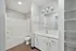Modern bathroom with sleek white fixtures, ample storage, and elegant lighting.