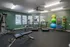 Modern fitness center featuring state-of-the-art exercise equipment, vibrant green walls, and a well-lit, spacious layout.