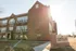 Charming brick building of Florence Fay Senior Apartments, basked in warm sunlight, showcasing its historic architectural elegance.