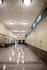 Bright and spacious corridor with shuffleboard court, modern overhead lighting, and sleek tile floor for recreational appeal.