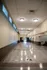 Spacious and bright hallway with elegant ceiling lights, featuring a shuffleboard court in a modern apartment building.