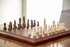 Elegant wooden chess set on a polished table, embodying classic strategy and timeless sophistication.