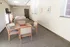 Bright lounge area featuring elegant seating, a modern chess table, and tasteful wall art, ideal for relaxation and entertainment.