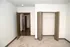 Inviting apartment with soft carpet flooring, open closet space, and warm, neutral tones ideal for personalization.