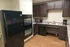 Modern kitchen featuring sleek black appliances, dark wood cabinetry, and a spacious countertop for stylish functionality.