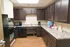 Modern kitchen with dark wood cabinetry, sleek granite countertops, and stainless steel appliances, offering functionality and style.