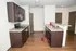Modern kitchen with sleek dark cabinetry, granite countertops, and stainless steel appliances, featuring a spacious layout ideal for culinary enthusiasts.