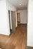 Inviting hallway with rich wooden flooring leading to spacious rooms, complemented by sleek interior doors.