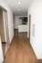 Inviting hallway leading to a modern kitchen with hardwood floors and sleek cabinetry.
