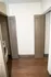 Modern laundry area with sleek brown double doors and a compact washer, offering efficient use of space.