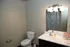 Bright and modern bathroom featuring sleek white fixtures, a stylish vanity with a large mirror, and a colorful shower curtain for a vibrant touch.