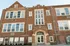 Charming red brick building with large windows and elegant entrance, ideal for modern urban living.